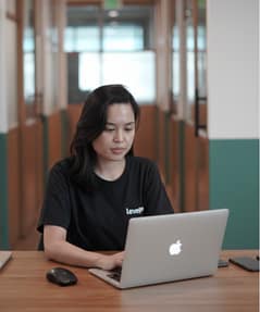 LevelUp team member focused on work at a laptop in a shared workspace.