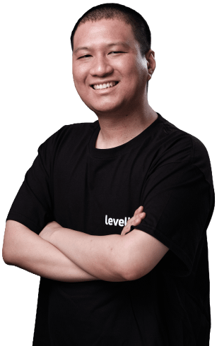 A smiling operations manager in a black LevelUp shirt, standing with arms crossed.