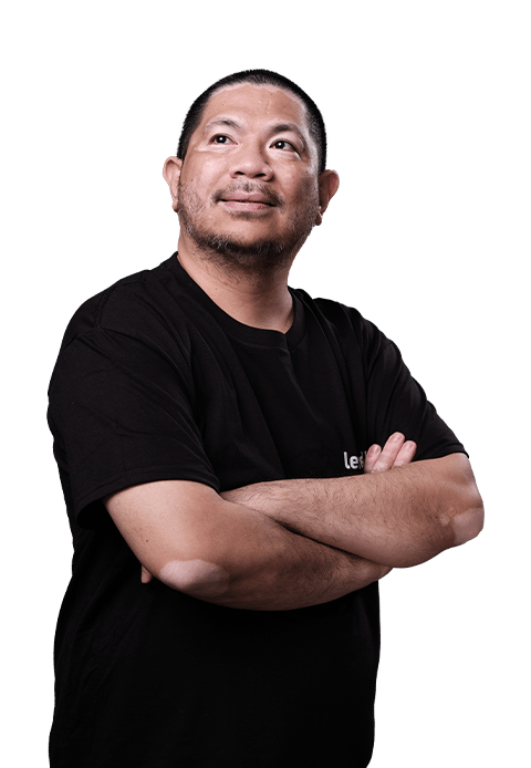 A finance professional standing confidently with arms crossed, wearing a black LevelUp shirt.