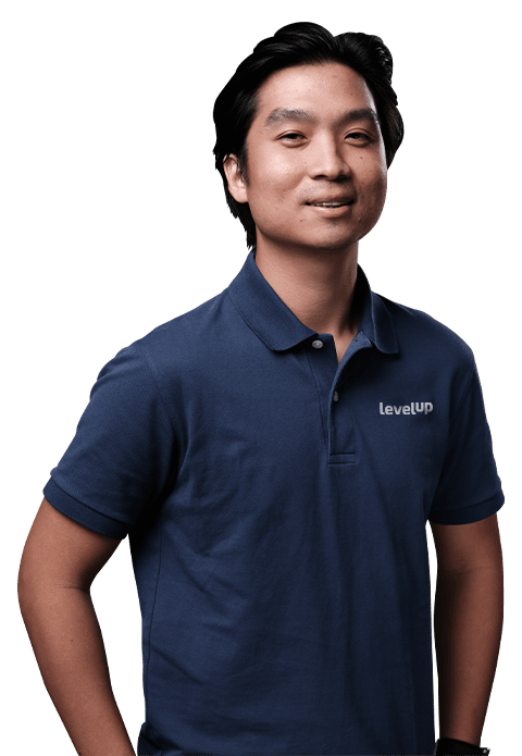 A professional wearing a navy blue polo shirt, standing and smiling confidently.
