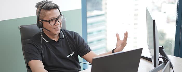 Offshore Sales Agent Handling Client Calls A LevelUp sales agent wearing a headset, engaged in a virtual call.