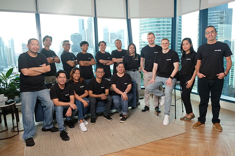 Group photo of LevelUp team members in black shirts, posed in a modern office setting in the Philippines. 