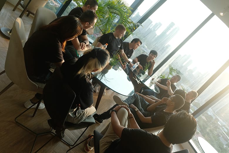 LevelUp team members engaged in a collaborative discussion in a bright office with city views.