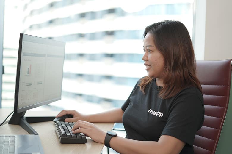 Offshore Tax Accountant Analyzing Financial Data A LevelUp tax accountant working on financial reports at her computer, reviewing spreadsheets and tax compliance data in a professional office setting.
