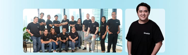 Group photo of LevelUp team members with a portrait of John Carlo