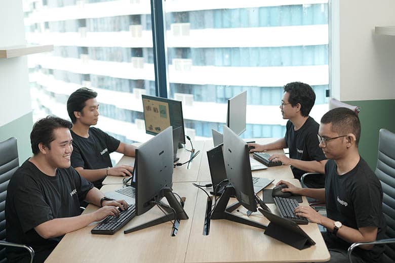 Data entry Team of LevelUp offshore digital marketing specialists collaborating at a shared workspace, focused on their tasks with modern equipment and a productive environment.