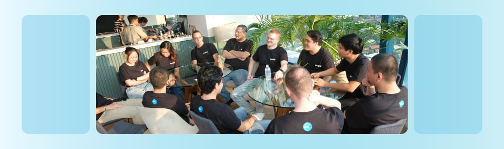 Photo of a group of LevelUp team members sitting together at a table outdoors, talking during a team meetup.